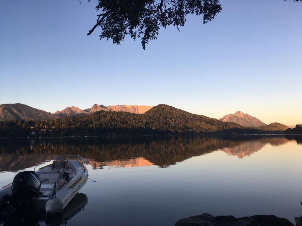 圣卡洛斯-德巴里洛切Albanta casa con costa en Bariloche的坐在山 ⁇ 的湖面上的船