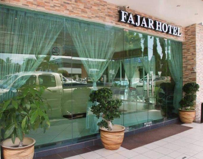 拿笃Fajar Hotel的商店橱窗里汽车的反射