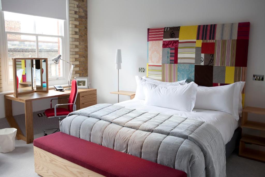 伦敦Boundary Shoreditch的一间卧室配有一张床、一张桌子和一把椅子