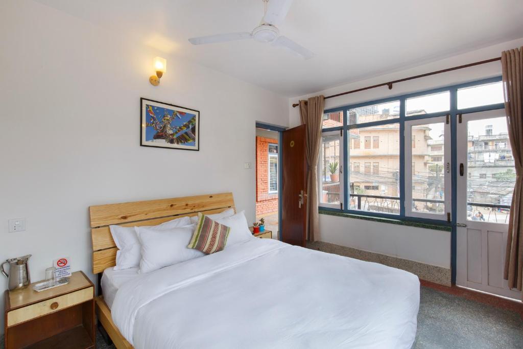 加德满都Pacific Guest House的卧室设有一张白色大床和一扇窗户。