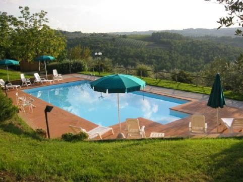 因普鲁内塔伊尔卡萨隆度假屋的一个带椅子和遮阳伞的大型游泳池