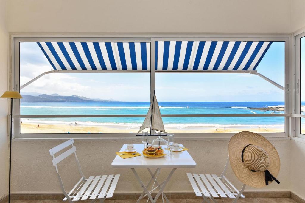 大加那利岛拉斯帕尔马斯拉斯坎特拉斯海滨公寓的一张桌子和椅子,享有海滩美景