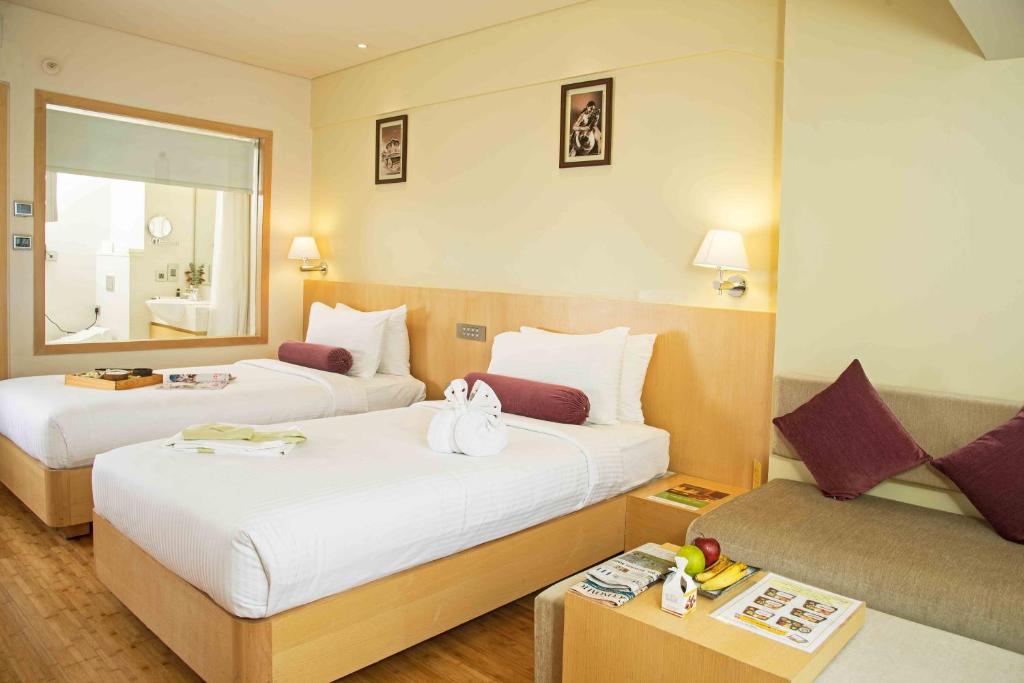 班加罗尔奇安瑟瑞酒店 的酒店客房,设有两张床和一张沙发