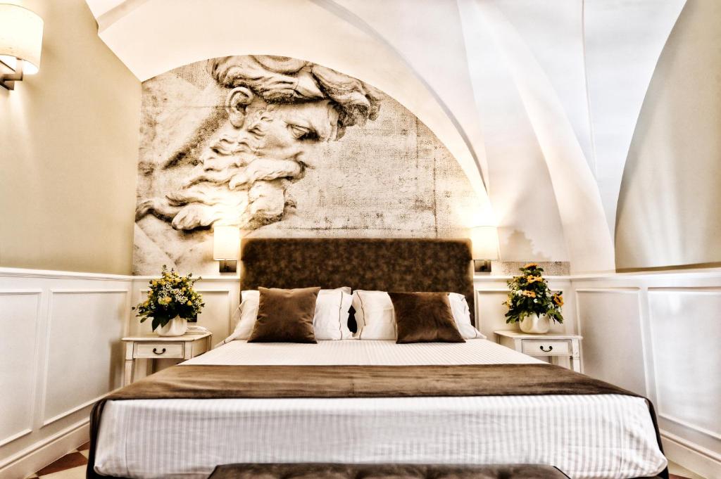 莫托拉卡萨伊莎贝拉高级酒店的一间卧室配有一张带雕塑墙的床