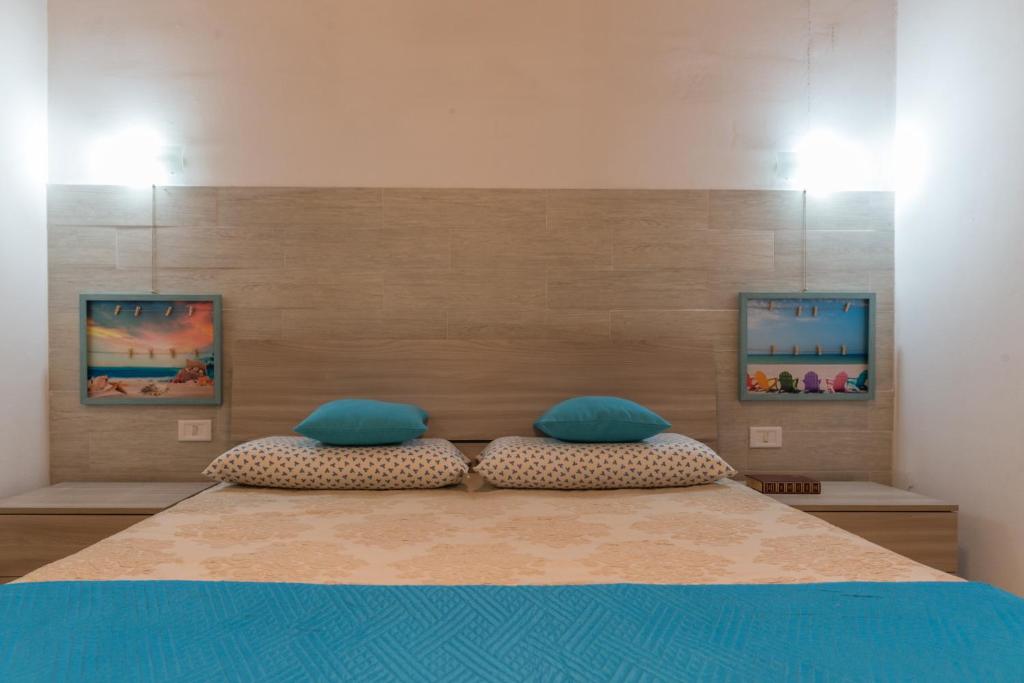普罗斯西托角Villetta Lana 1DX的一间卧室配有一张带蓝色枕头的大床