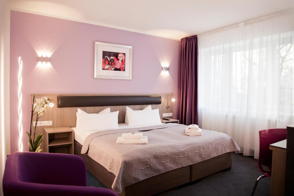 柏林尼古拉公寓酒店的酒店客房,配有一张床和两把椅子