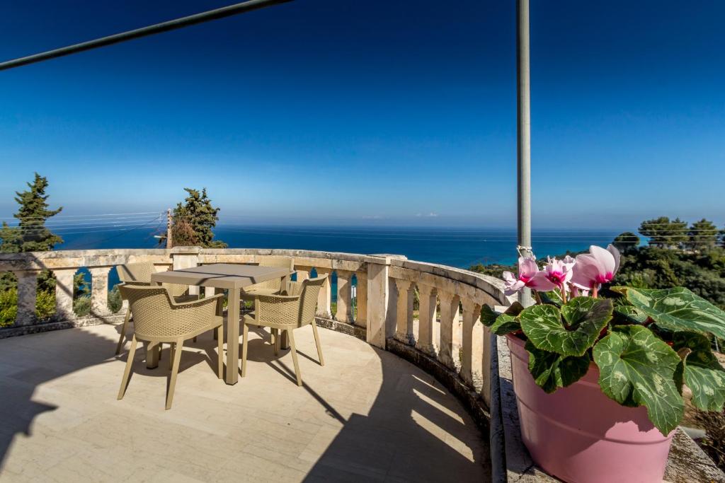 瓦西里科斯蓝色地平线公寓的一个带桌椅的庭院和大海