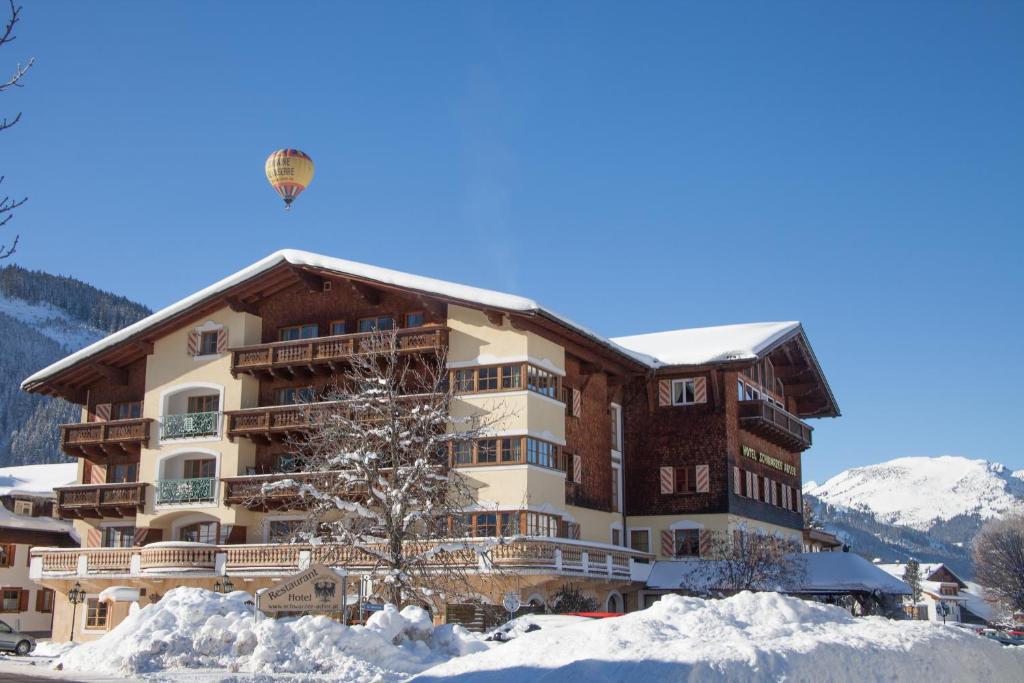 坦海姆Das Traditionshotel Schwarzer Adler的一座带热气球的雪地建筑