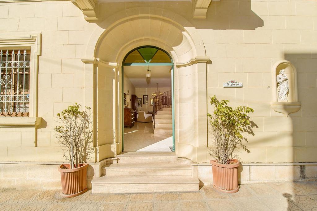 休吉让塔约瑟夫酒店的两株盆栽植物的建筑物入口