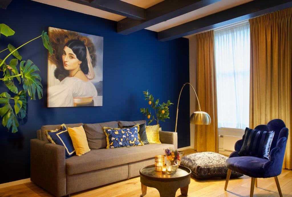 哈莱姆Haarlem Hotel Suites的客厅配有沙发和一幅女人画