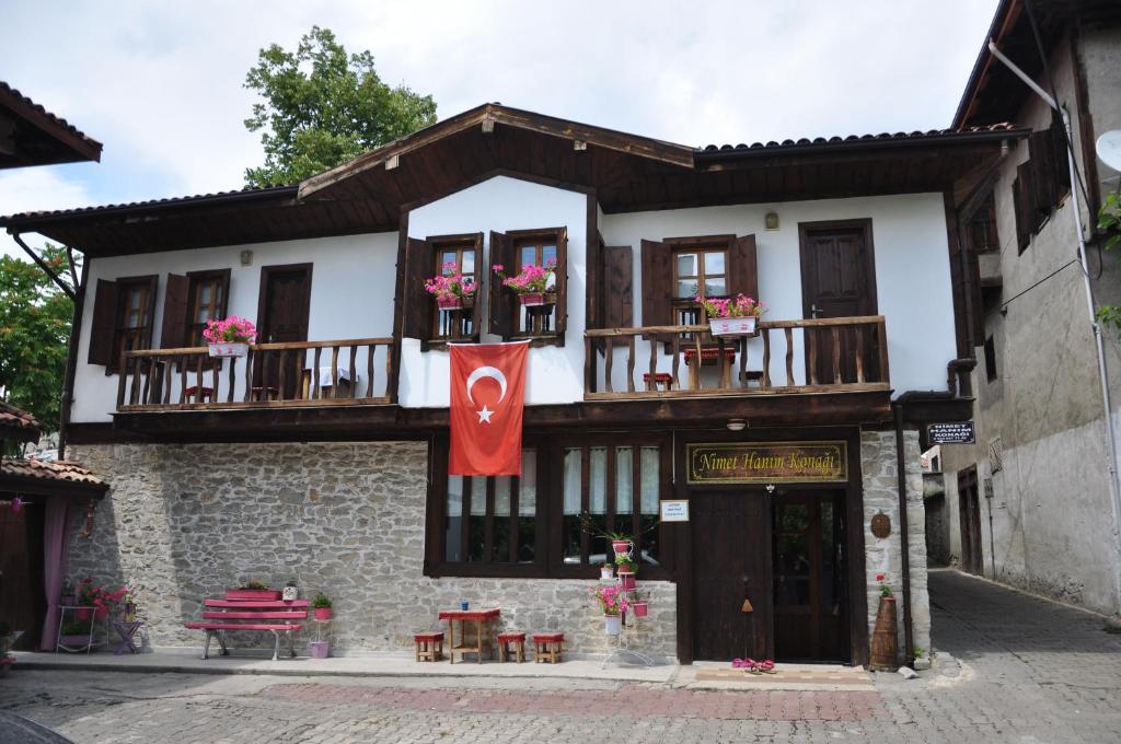 番红花城Nimet Hanım Konağı的前面有旗帜的建筑