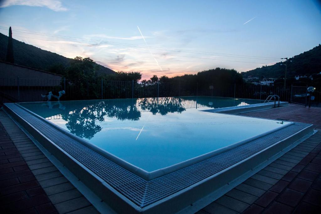 尼斯波特Vistamare La Fonte的水面上映着天空的游泳池