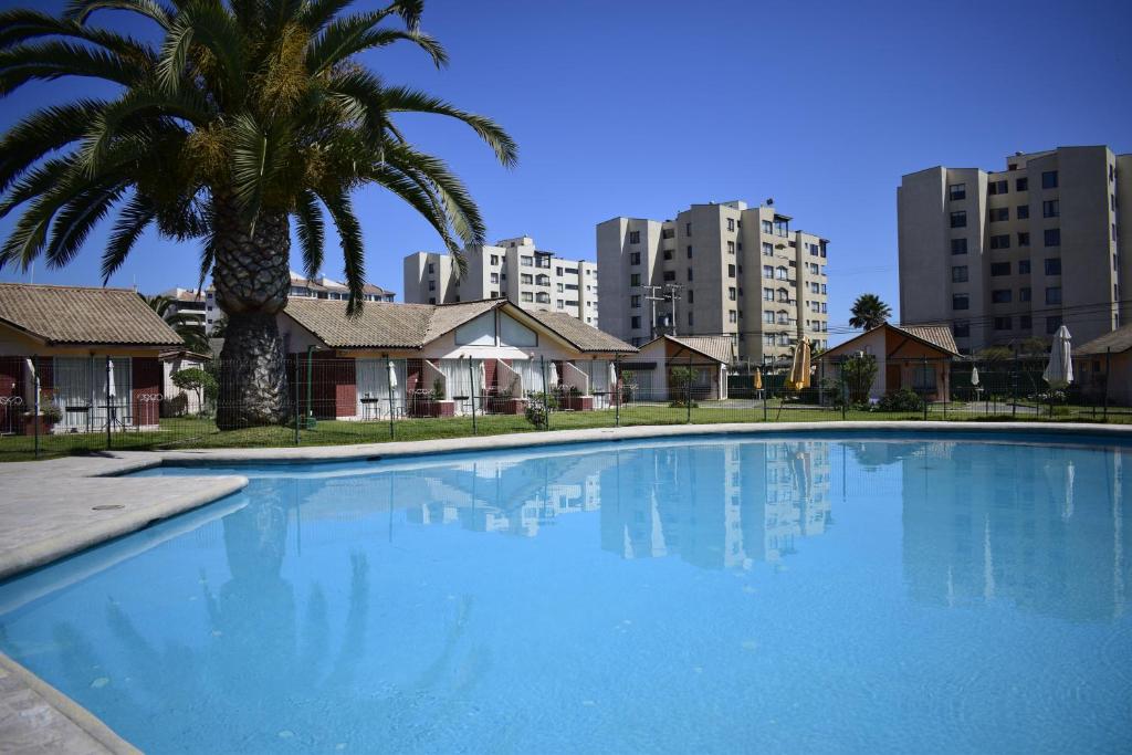 拉塞雷纳卡巴纳斯维嘉苏度假屋的一座棕榈树和建筑的大型游泳池