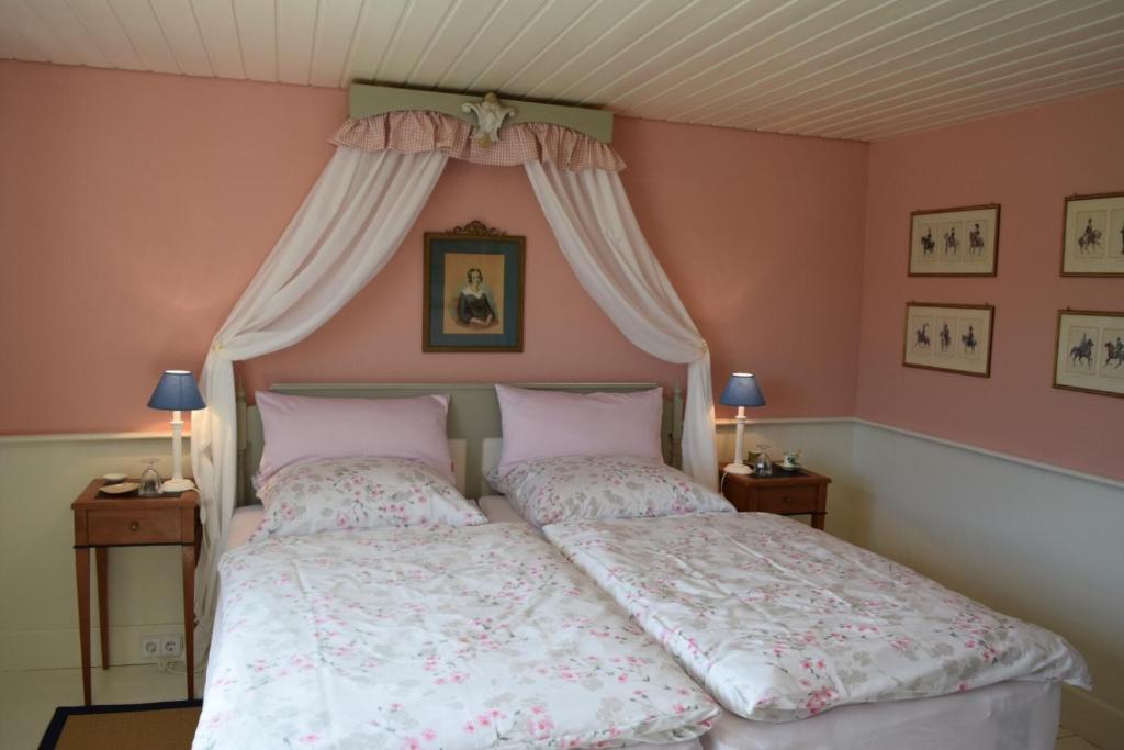 塞勒姆Bed & Breakfast mit Charme- Aux2platanes- Außergewöhnlich schön am Bodensee的卧室配有一张带粉红色墙壁的大床