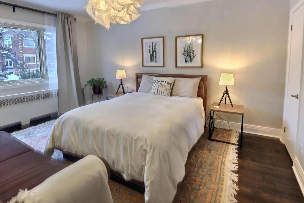 蒙特利尔Gite du Survenant Montreal的一间卧室配有一张大床和两盏灯。
