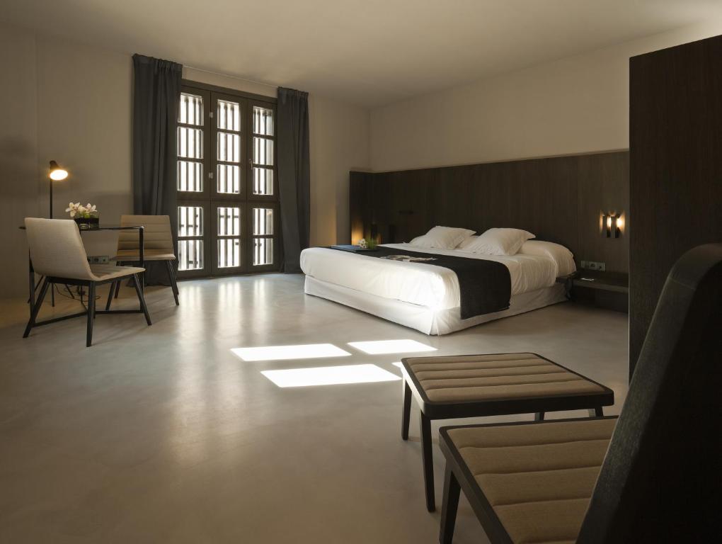瓦伦西亚卡罗酒店的一间卧室配有一张大床和一张桌子及椅子