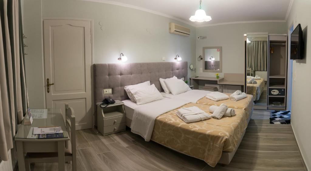 米蒂利尼阿卡利迪酒店的一间卧室配有两张带白色枕头的床。