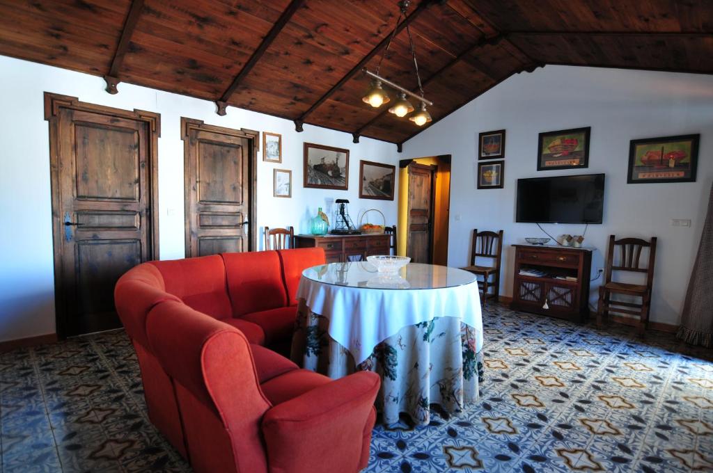 Zalamea la RealEl Romerito的客厅配有红色的沙发和桌子