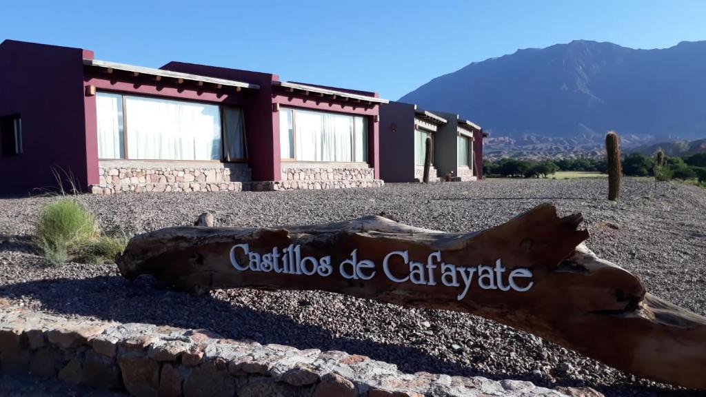 卡法亚特Hotel Castillos de Cafayate的坐在楼前地面上的木头