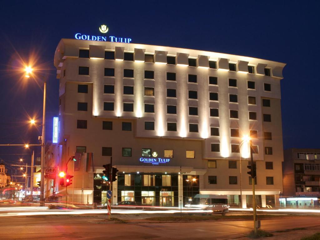 瓦尔纳Hotel Golden Tulip Varna的一座建筑物,上面有夜间标志