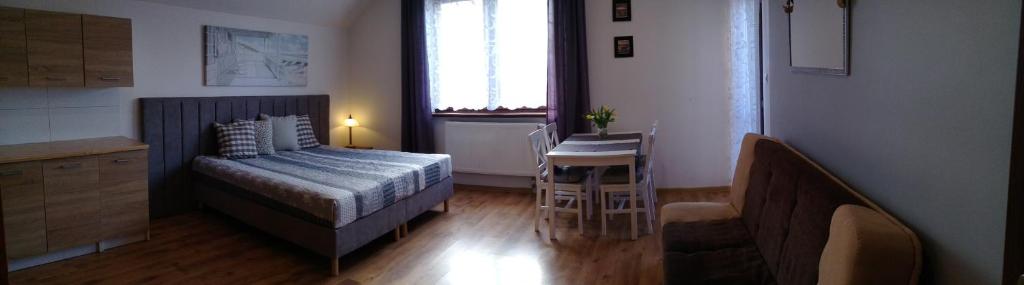 尤斯托尼莫斯基Domki letniskowe i pokoje u Katarzyny的一间卧室配有一张床、一张桌子和一个窗户。