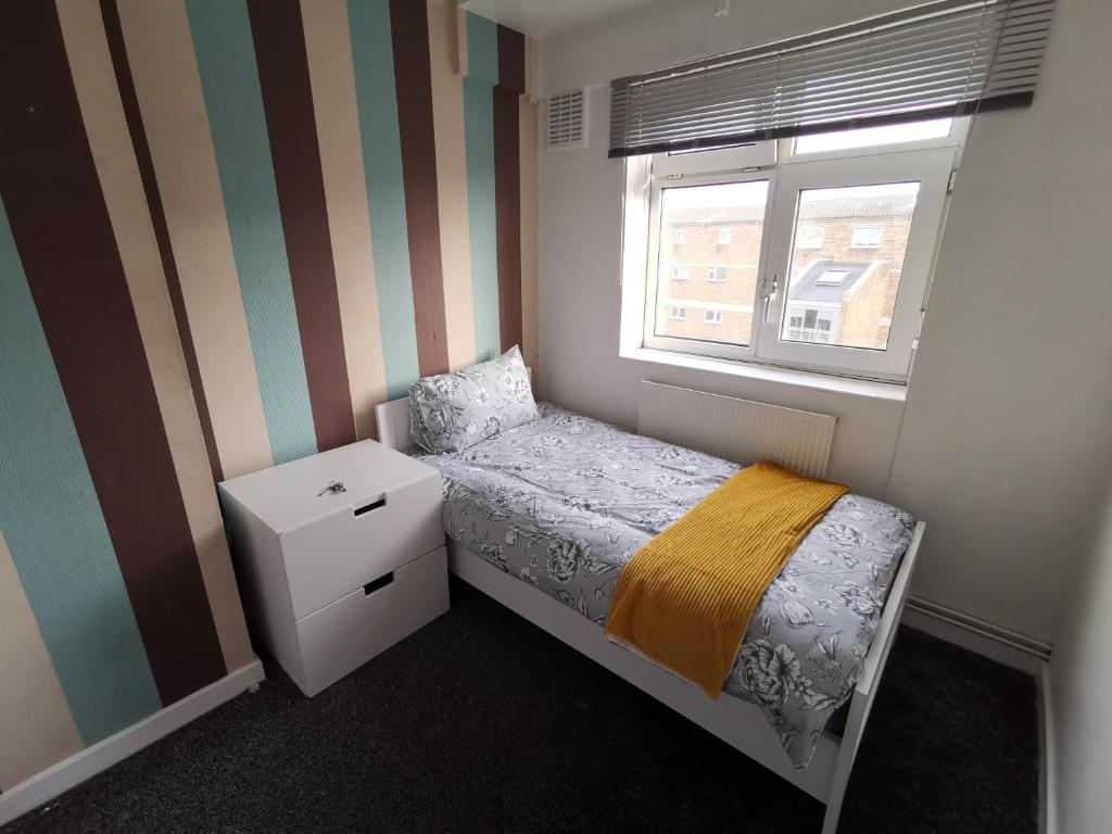 伦敦London budget Maisonette的一间小卧室,配有床和窗户
