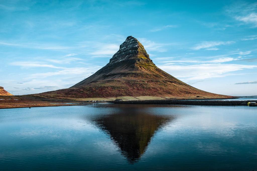 格仑达积图Kirkjufell Hotel by Snæfellsnes Peninsula West Iceland - Grundarfjordur的山 ⁇ ,坐在水体旁