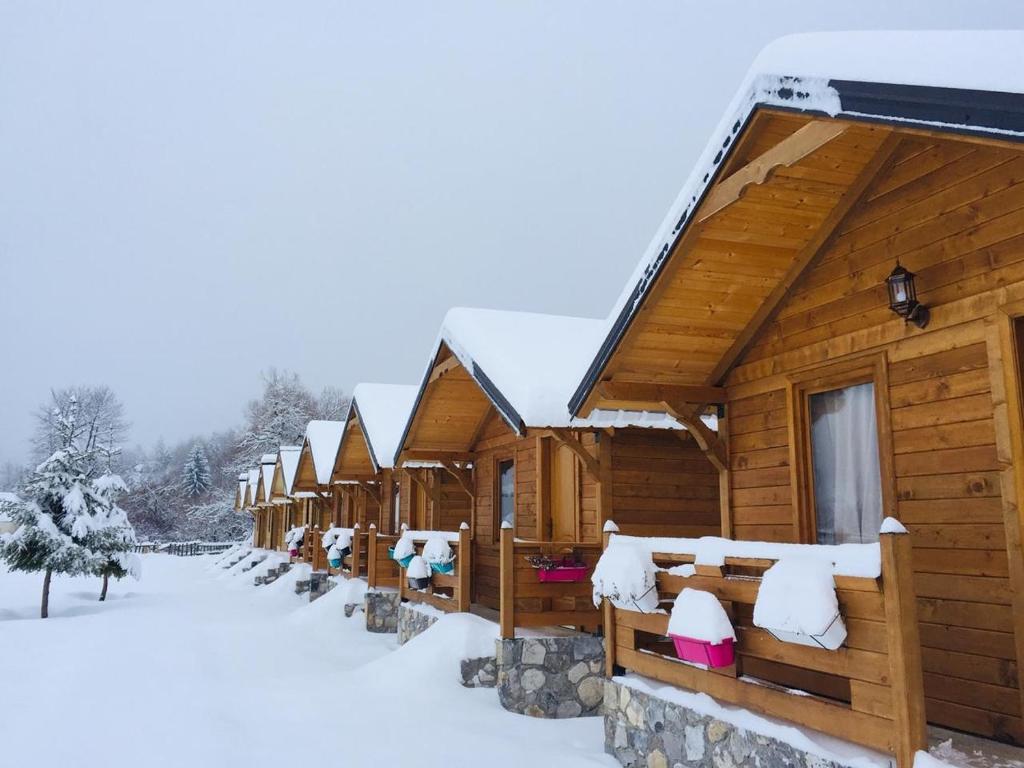 瓦勒博内Villas Jezerca的雪中一排小木屋