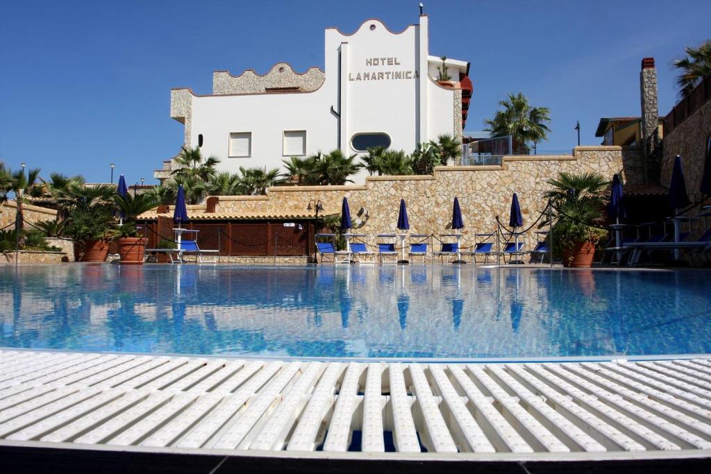 Ficarazzi马提尼克酒店的一座带椅子的大型游泳池和一座建筑
