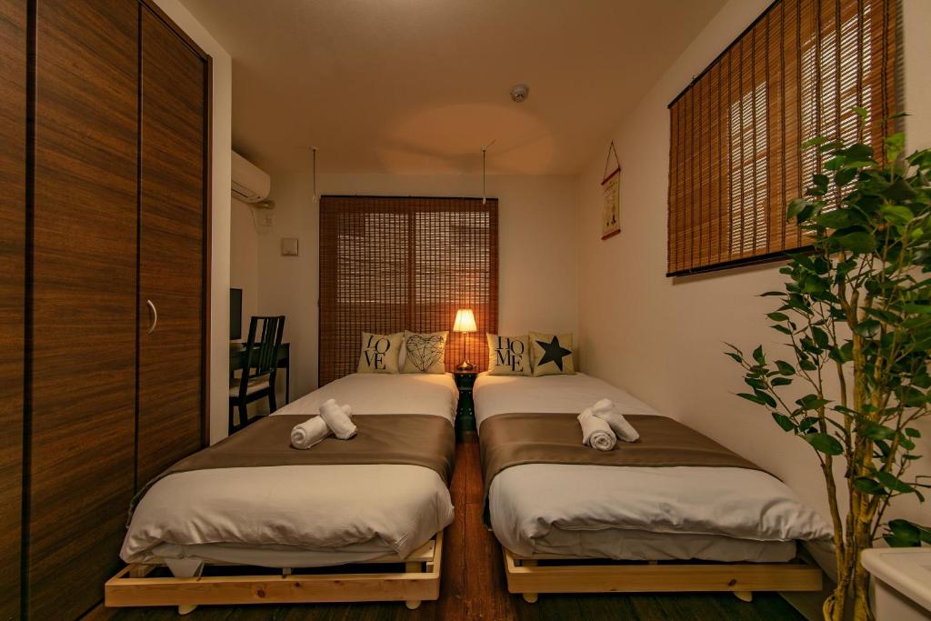 堺市高地HANA公寓的带灯的客房内的两张单人床
