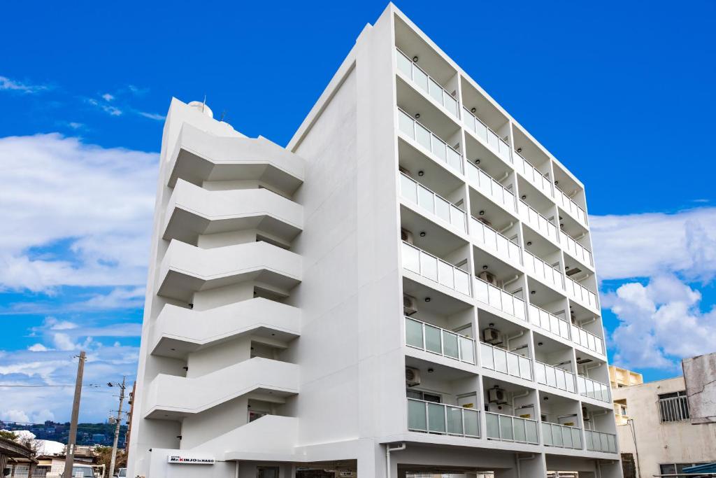 名户Condominium Hotel Likka in Nago的带阳台的白色建筑和蓝天