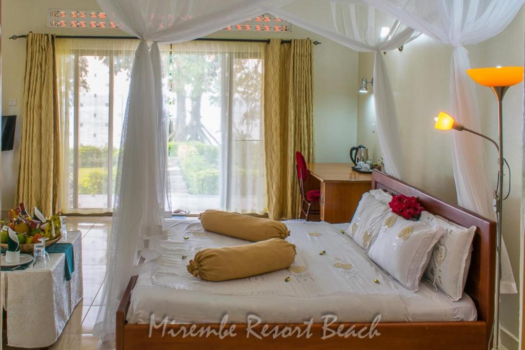 KalangalaMirembe Resort Beach Hotel Ssese的一间卧室配有一张白色天蓬床