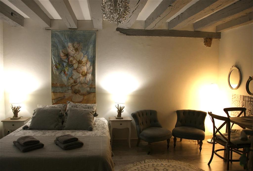 布鲁瓦切斯布鲁诺埃特弗朗西丝酒店的一间卧室配有一张床和两把椅子,墙上挂着一幅画