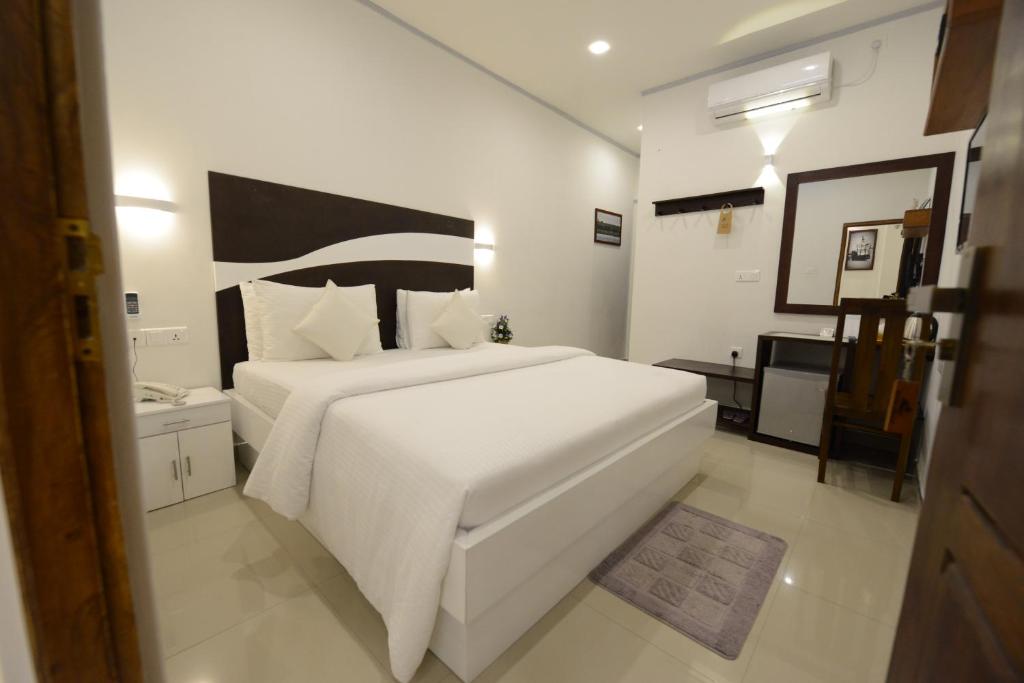 卡图纳耶克迪瓦别墅机场转机酒店的白色卧室配有一张白色的大床