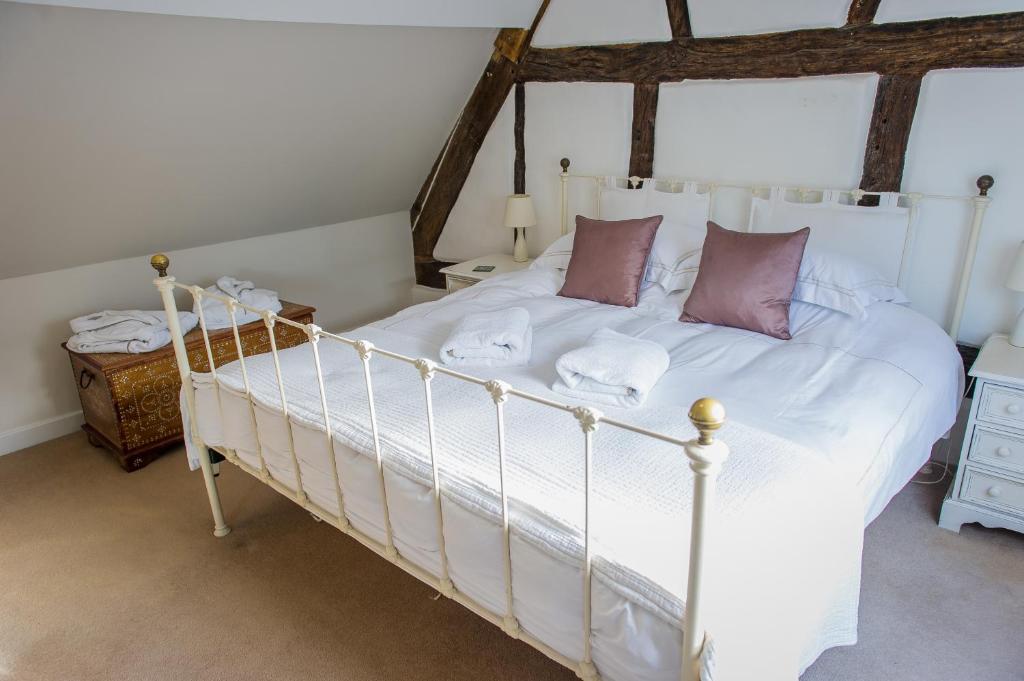 韦姆Narnia的一间卧室配有一张带白色床单和紫色枕头的床