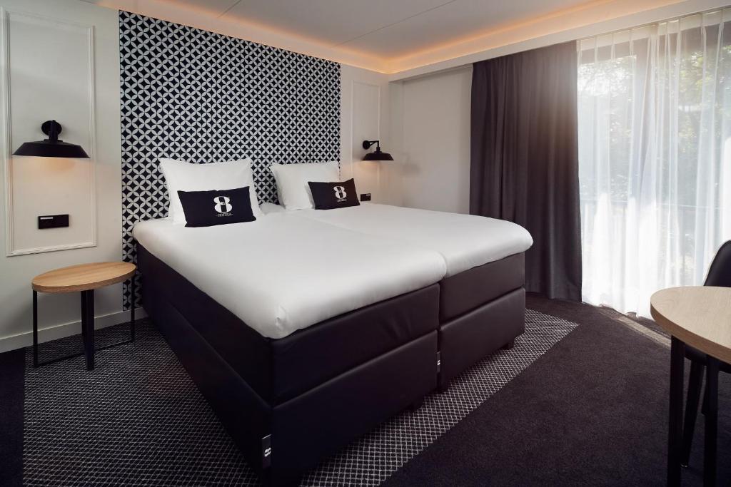 阿姆斯特丹Gr8 Hotel Amsterdam Riverside的酒店客房设有一张大床和一张桌子。