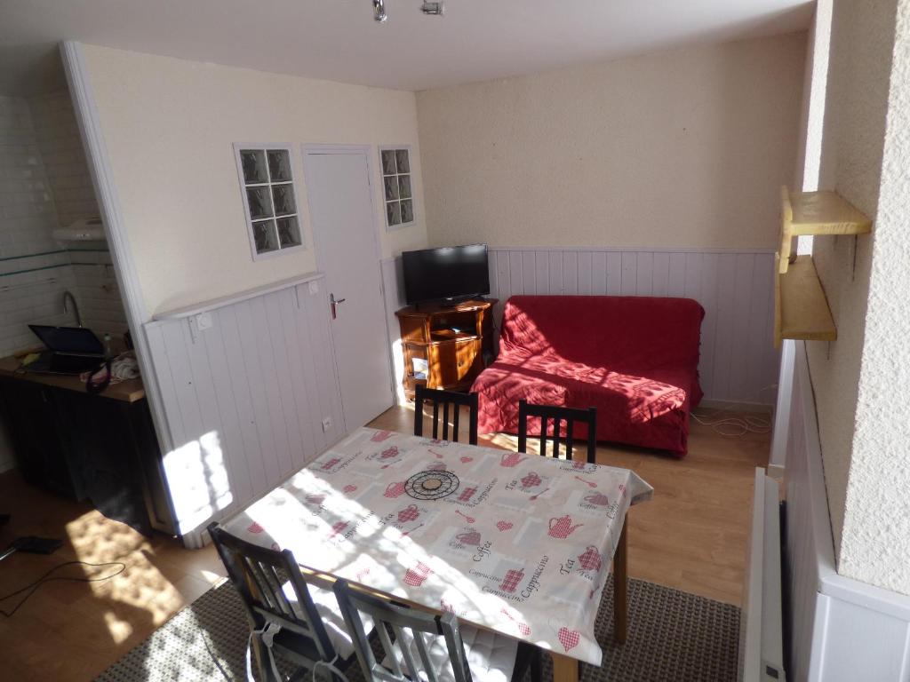 欧波讷Appartement de la cascade的客厅配有桌子和红色沙发