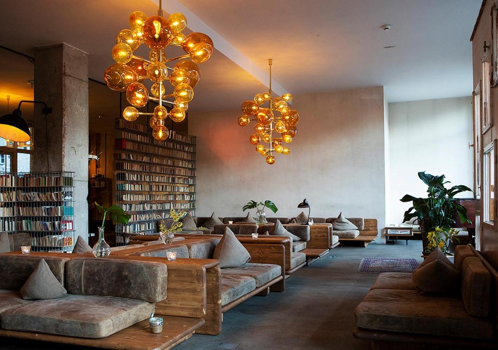 柏林米赫尔伯格酒店的一间配有沙发和吊灯的图书馆