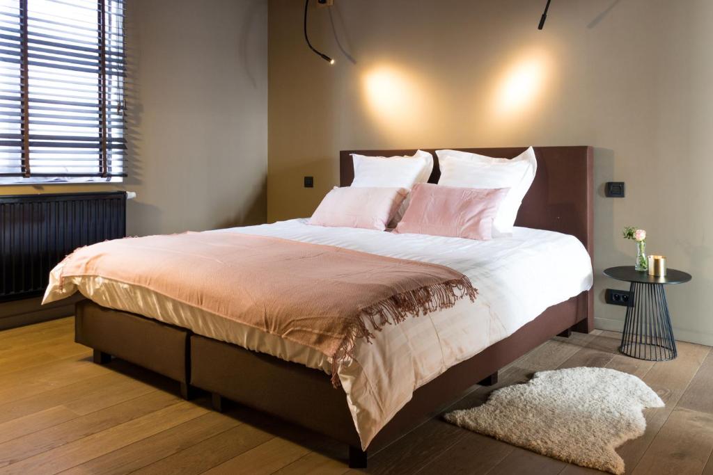 根特Brabantdam 84/2的卧室配有一张带粉红色枕头的大床