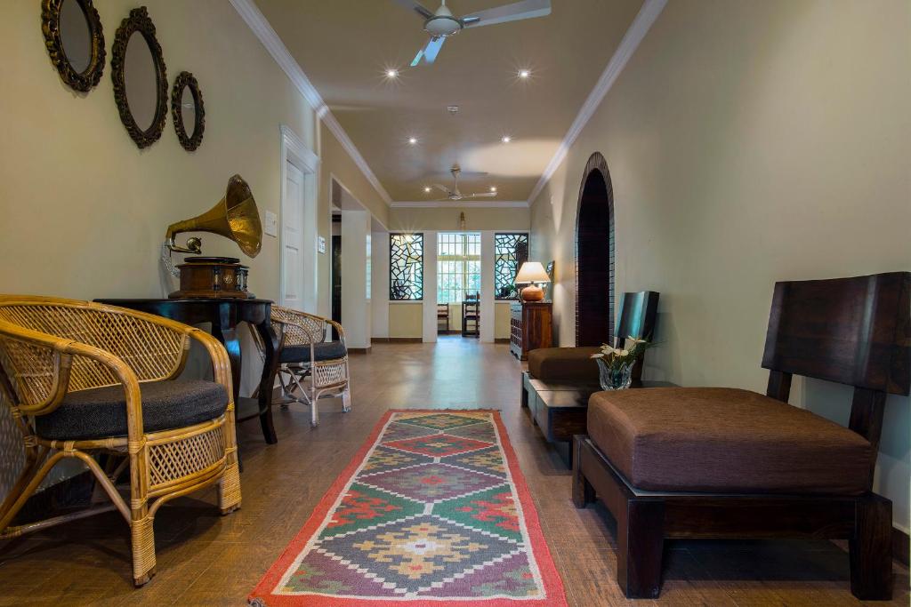 提喀迪Alencherry plantation homestay的客厅配有桌椅和地毯
