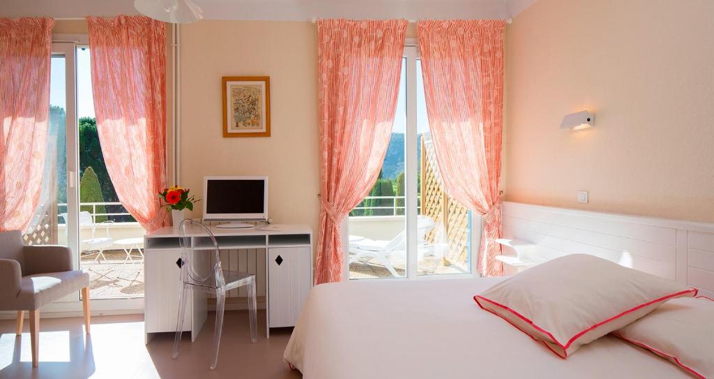 格雷乌莱班韦尔东河酒店的一间卧室配有一张床、一张书桌和一个窗户。