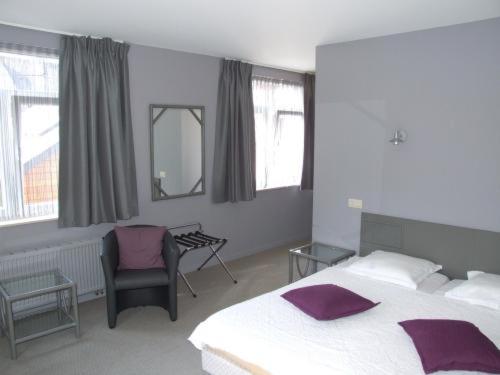 韦兰健康酒店的一间卧室配有一张床、一把椅子和窗户。