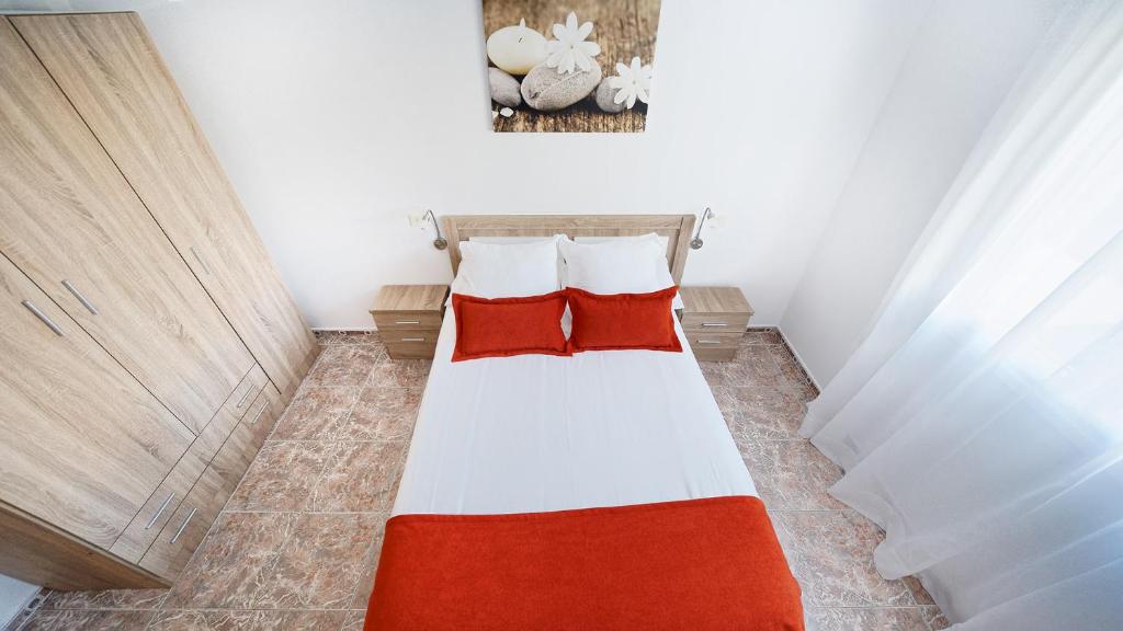 阿里纳加Armonía Beach 104的小卧室配有红色枕头的床