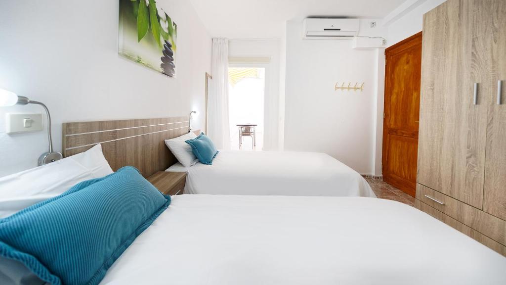 阿里纳加Armonía Beach 17的配有白色和蓝色枕头的客房内的两张床