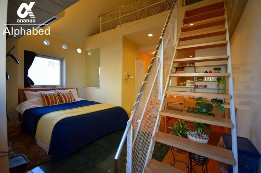 高松Alphabed TakamatsuKawaramachi 501 / Vacation STAY 21604的一间卧室设有一张床和一个螺旋楼梯