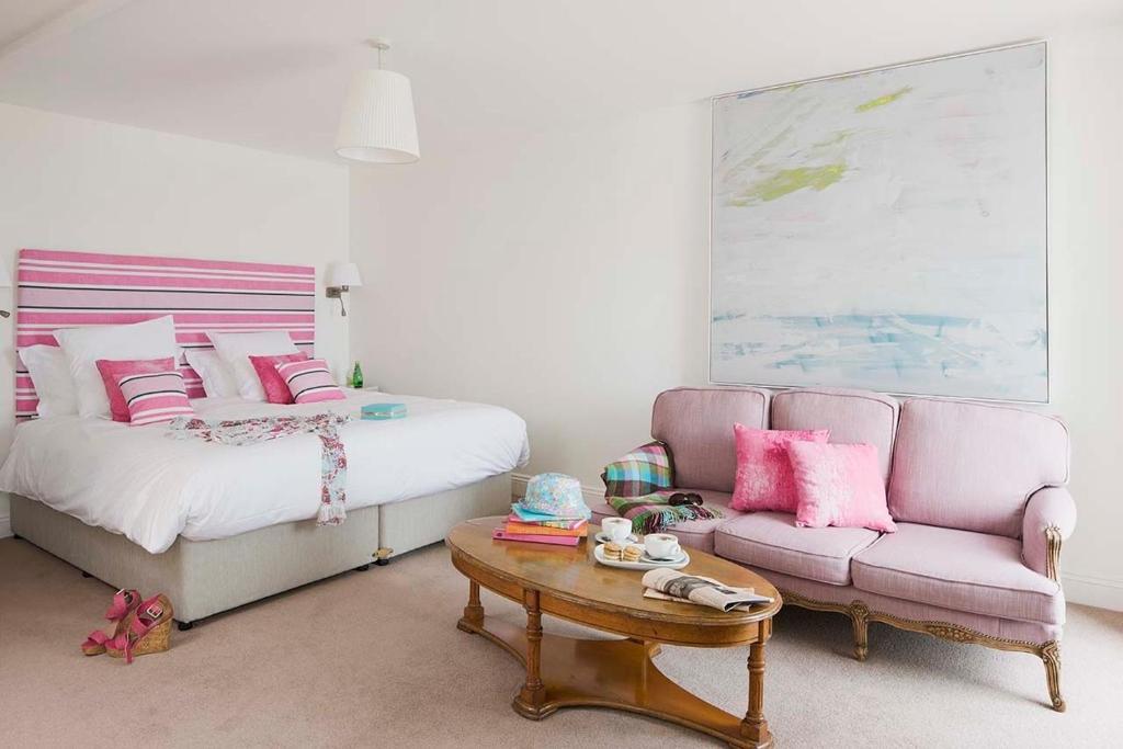 邓莫尔东斯特兰德酒店 的一间卧室配有一张床、一张沙发和一张桌子