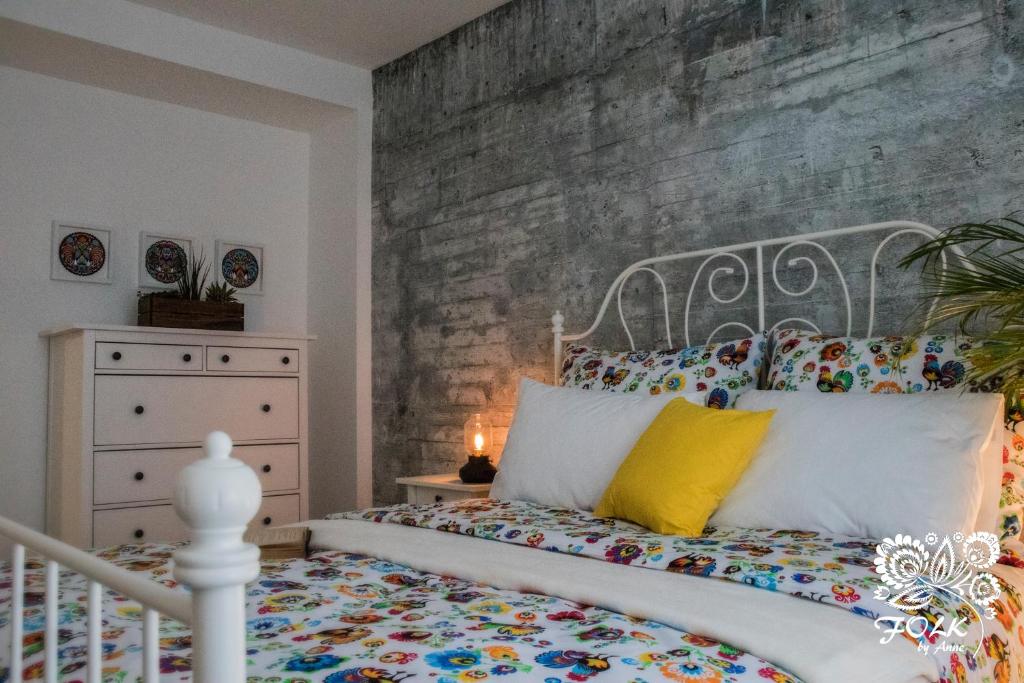 华沙Folk by Anne Apartments & Rooms的卧室配有白色的床和砖墙