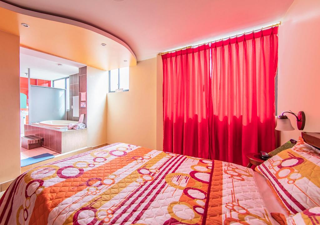 基多Hostal Oro Orense的一间卧室配有床和红色窗帘
