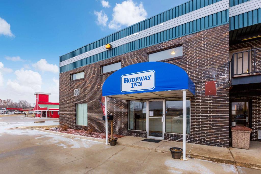 Sergeant BluffRodeway Inn Sergeant Bluff - Sioux City的一座砖砌的建筑,上面有蓝色遮阳篷