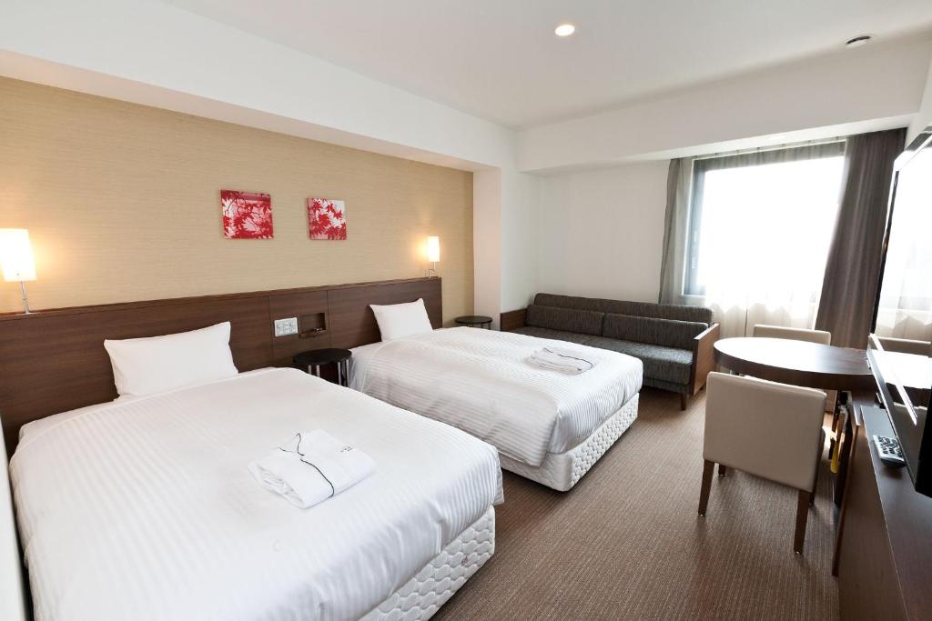 柏市千叶柏市索特图斯弗雷撒酒店的酒店客房设有两张床和一张桌子。